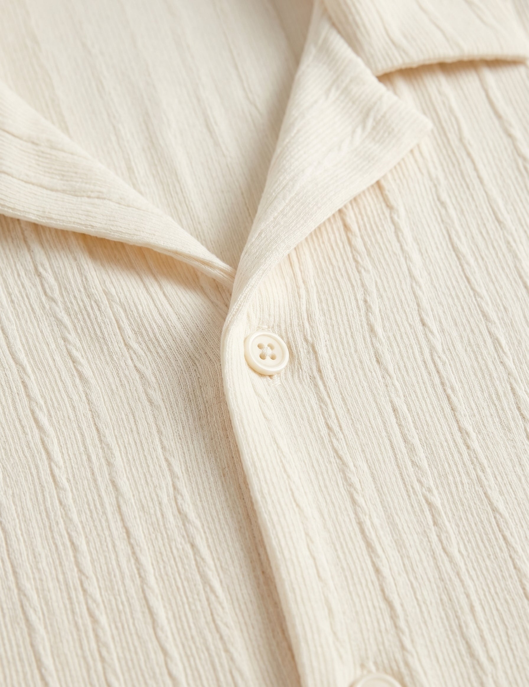 Close-up of a cream-colored shirt with buttons