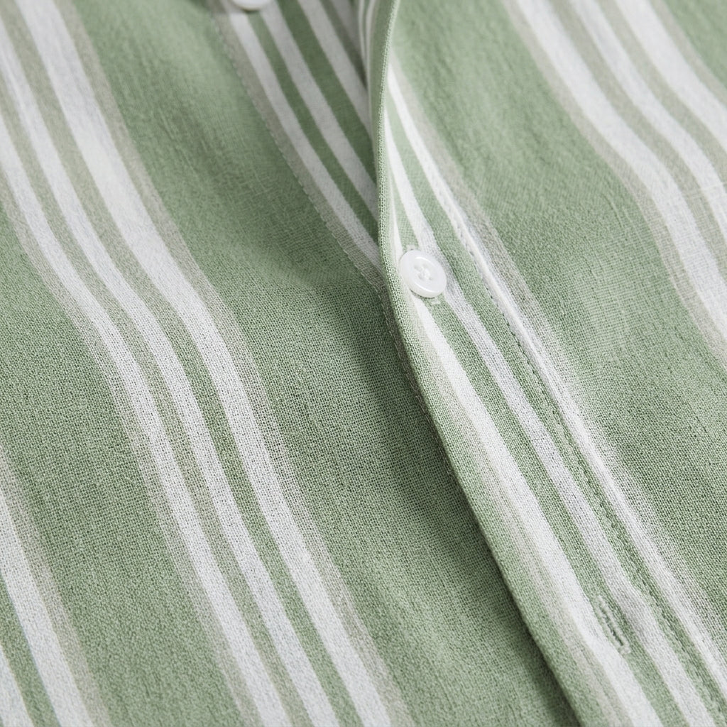 Close-up of a green and white striped fabric with buttons.