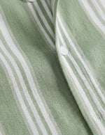 Close-up of a green and white striped fabric with buttons.