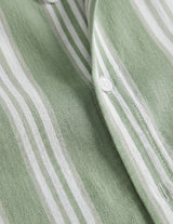 Close-up of a green and white striped fabric with buttons.