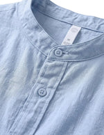Close-up of a light blue denim shirt with white buttons on a white background