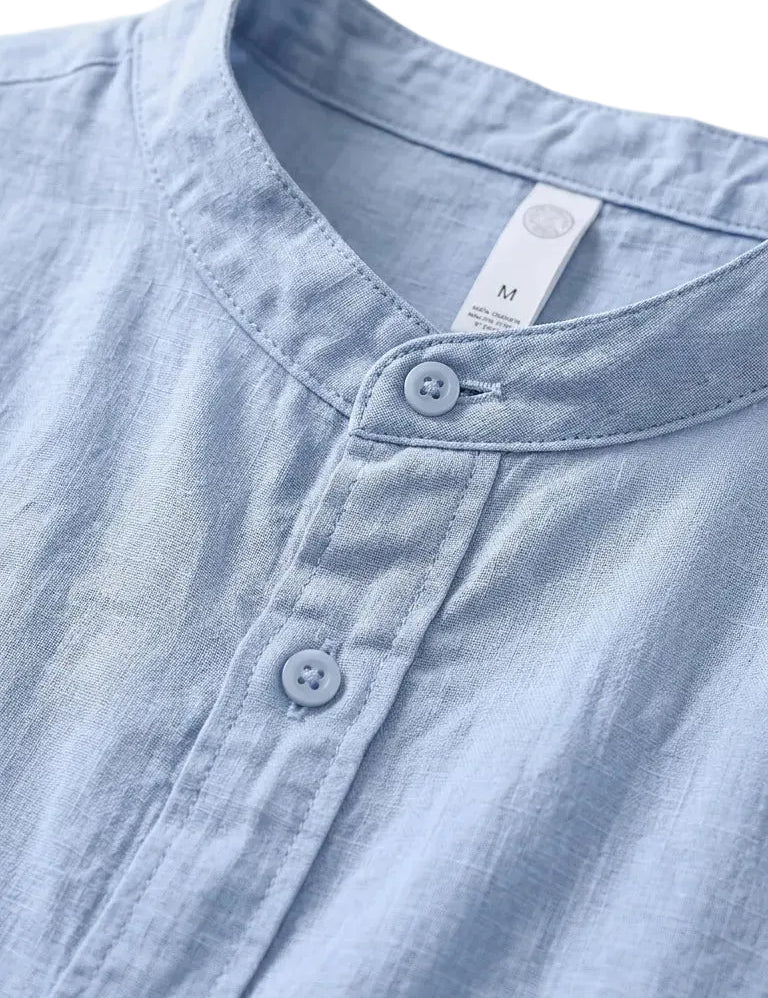 Close-up of a light blue denim shirt with white buttons on a white background
