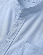 Close-up of a light blue shirt with a collar and button details.