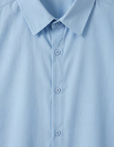 Close-up of a light blue shirt with collar and buttons