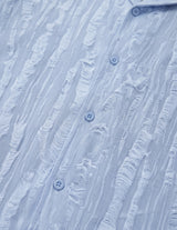 Close-up of a textured blue shirt with button details