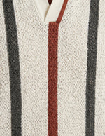 Close-up of a textured fabric with vertical stripes in black, red, and white.