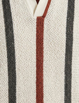 Close-up of a textured fabric with vertical stripes in black, red, and white.