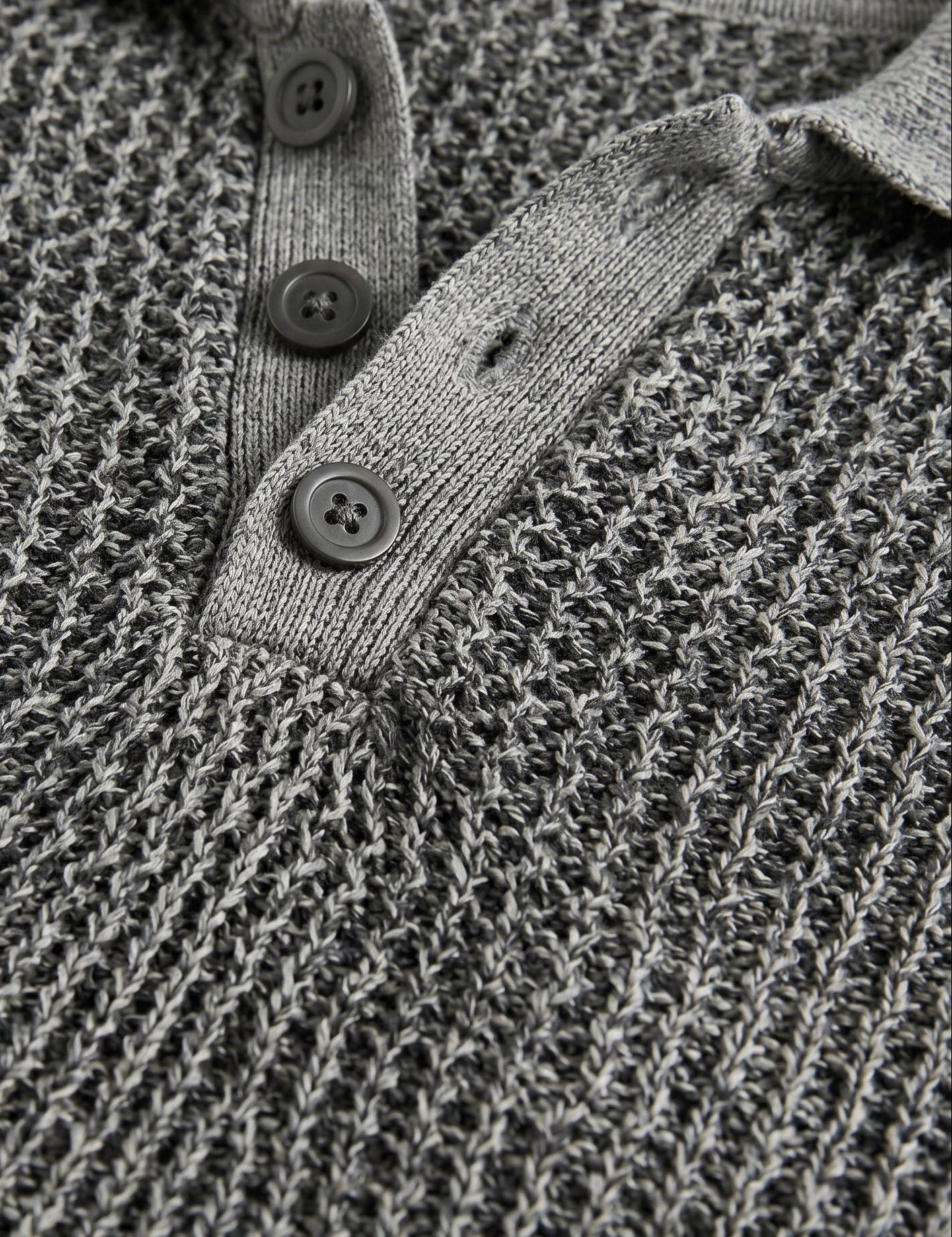 Close-up of a textured gray sweater with button details