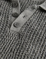 Close-up of a textured gray sweater with button details