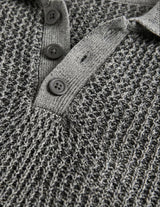Close-up of a textured gray sweater with button details