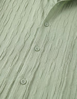 Close-up of a textured green shirt with button details