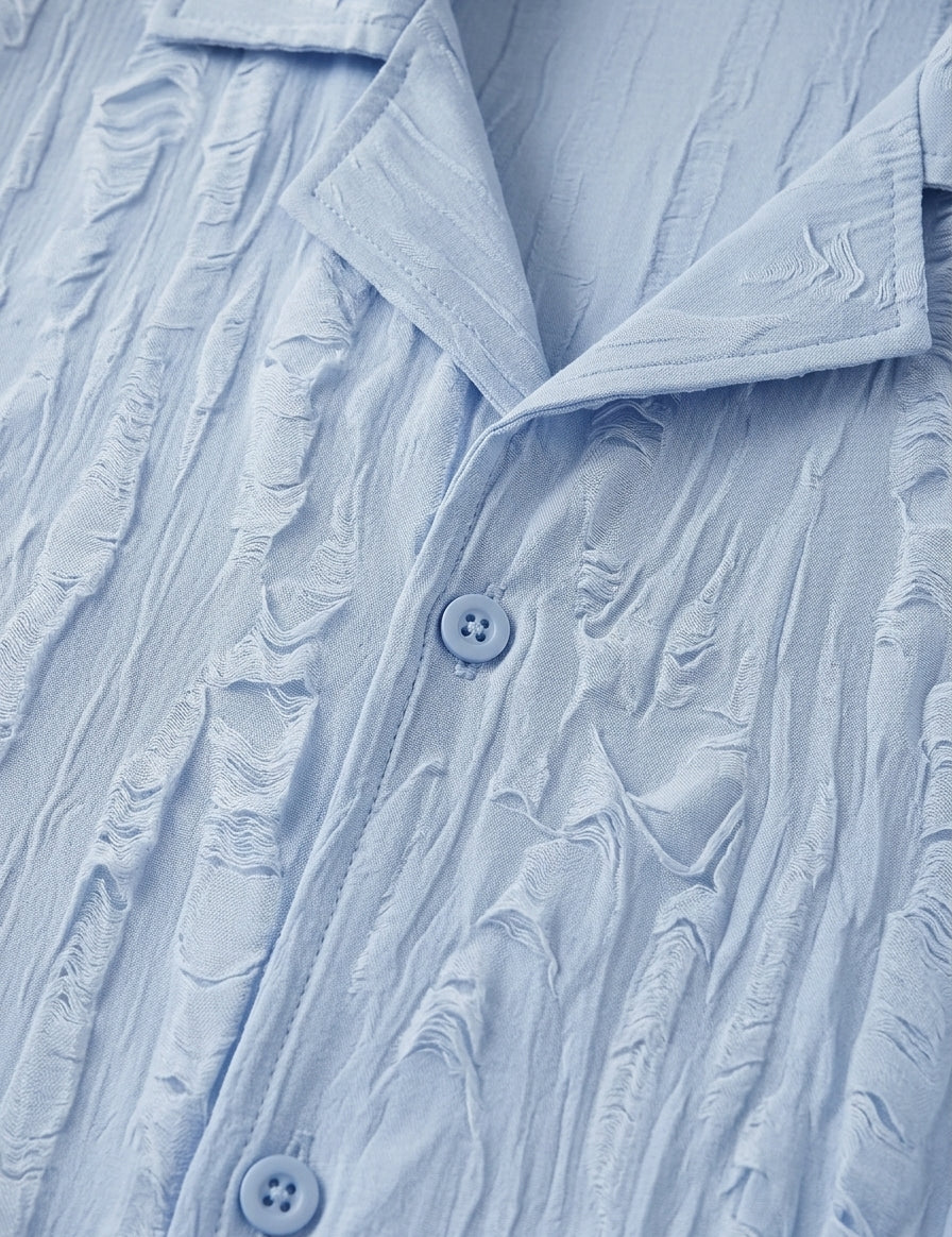 Close-up of a textured light blue shirt with buttons