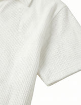 Close-up of a textured white shirt with short sleeves on a light gray background