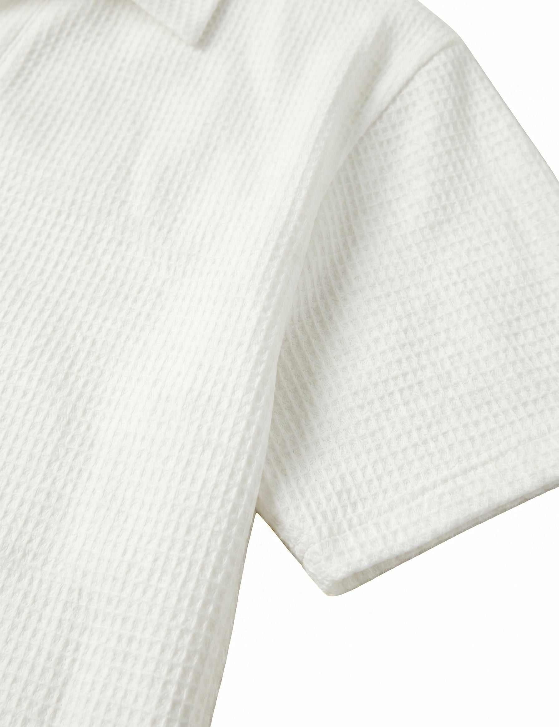 Close-up of a textured white shirt with short sleeves on a light gray background
