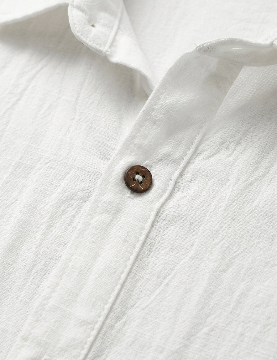 Close-up of a white shirt with a button on a light gray background