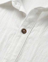 Close-up of a white shirt with a button on a light gray background