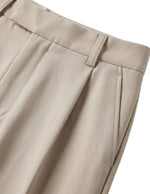 Close-up of beige pants on a light gray background