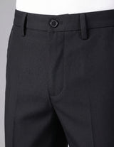 Close-up of black dress pants with a button on a gray background