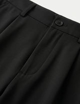 Close-up of black pants with a button on a light gray background