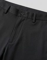 Close-up of black pants with a button on a light gray background