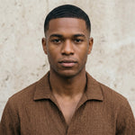 Close-up of male model wearing a brown textured short-sleeve collared shirt.