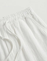 Close-up of white fabric with frayed edges on a light gray background