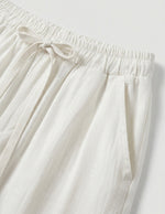 Close-up of white pants with an elastic waistband on a light gray background