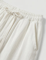Close-up of white pants with an elastic waistband on a light gray background