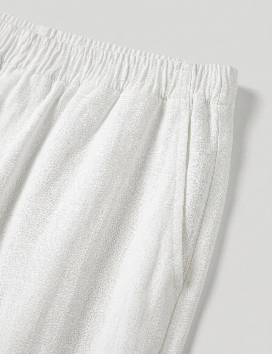Close-up of white pants with an elastic waistband on a light gray background