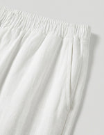Close-up of white pants with an elastic waistband on a light gray background