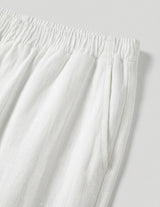 Close-up of white pants with an elastic waistband on a light gray background