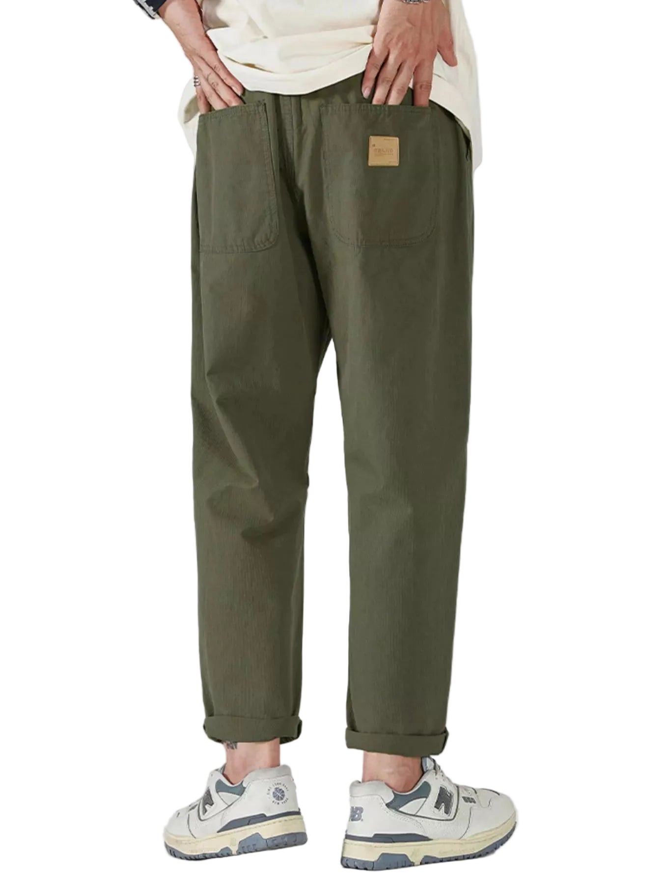 Close-up view of olive green jogger pants styled with a beige T-shirt and sneakers.