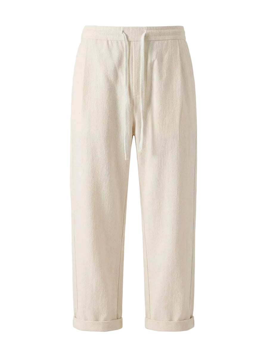 Cream drawstring jogger pants with tapered legs on a white background.