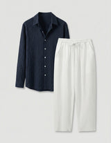 Dark blue shirt and white pants on a light gray background