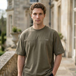 Front view of male model wearing an olive green oversized short-sleeve T-shirt with a relaxed fit.