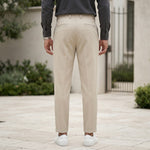 Full front view of male model wearing beige pleated pants with a dark gray long-sleeve shirt.