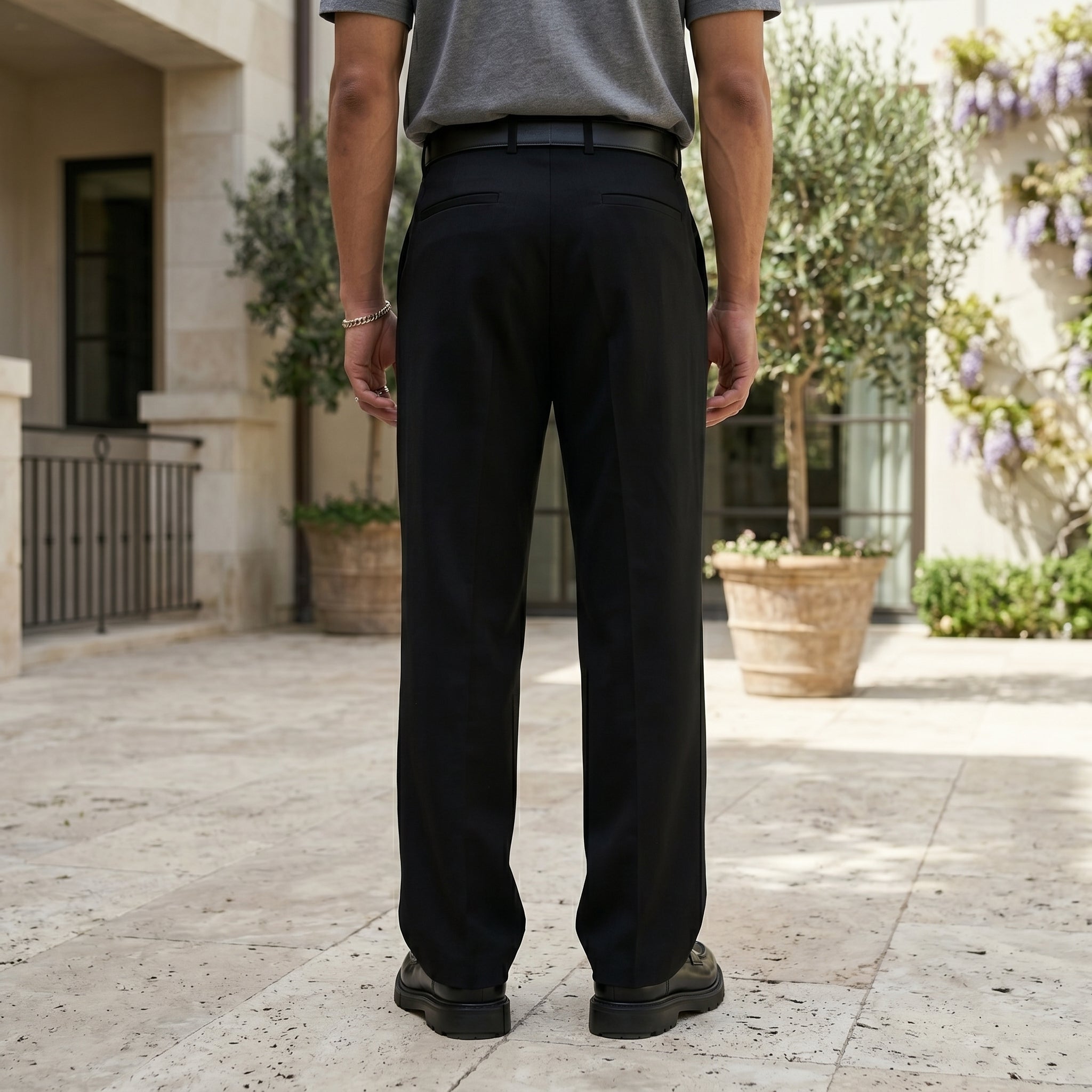 Full front view of male model wearing black pleated pants with a gray T-shirt.