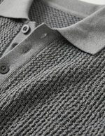 Graphite - Close-up of a textured gray sweater with a collar and buttons.