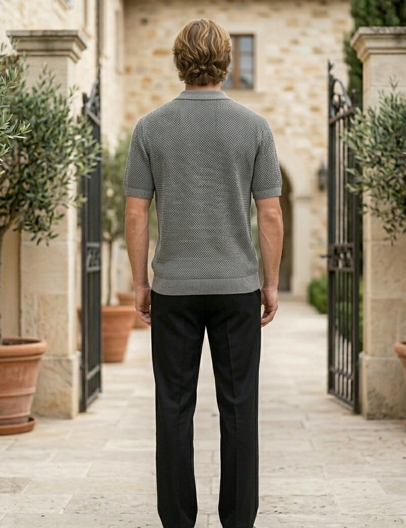 Graphite - Man standing in a courtyard with stone walls and potted plants