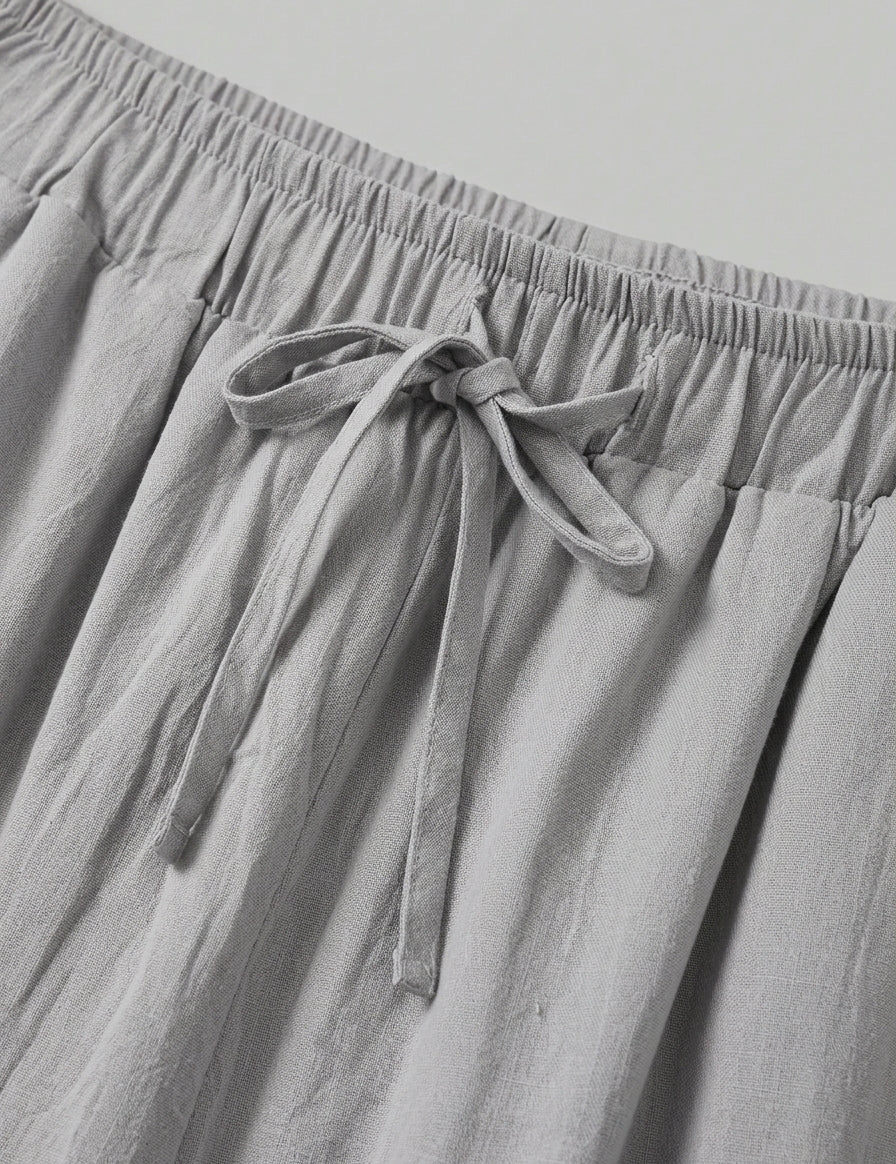 Gray pants with an elastic waistband and tie detail on a light gray background