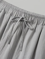 Gray pants with an elastic waistband and tie detail on a light gray background