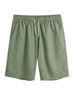 Green shorts with a drawstring on a light gray background