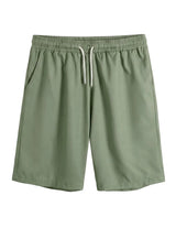 Green shorts with a drawstring on a light gray background