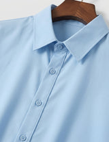 Light blue shirt on a wooden hanger against a white background