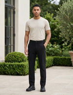 Man wearing a black men’s stretch pocketed pants with clean straight fit and button-front closure