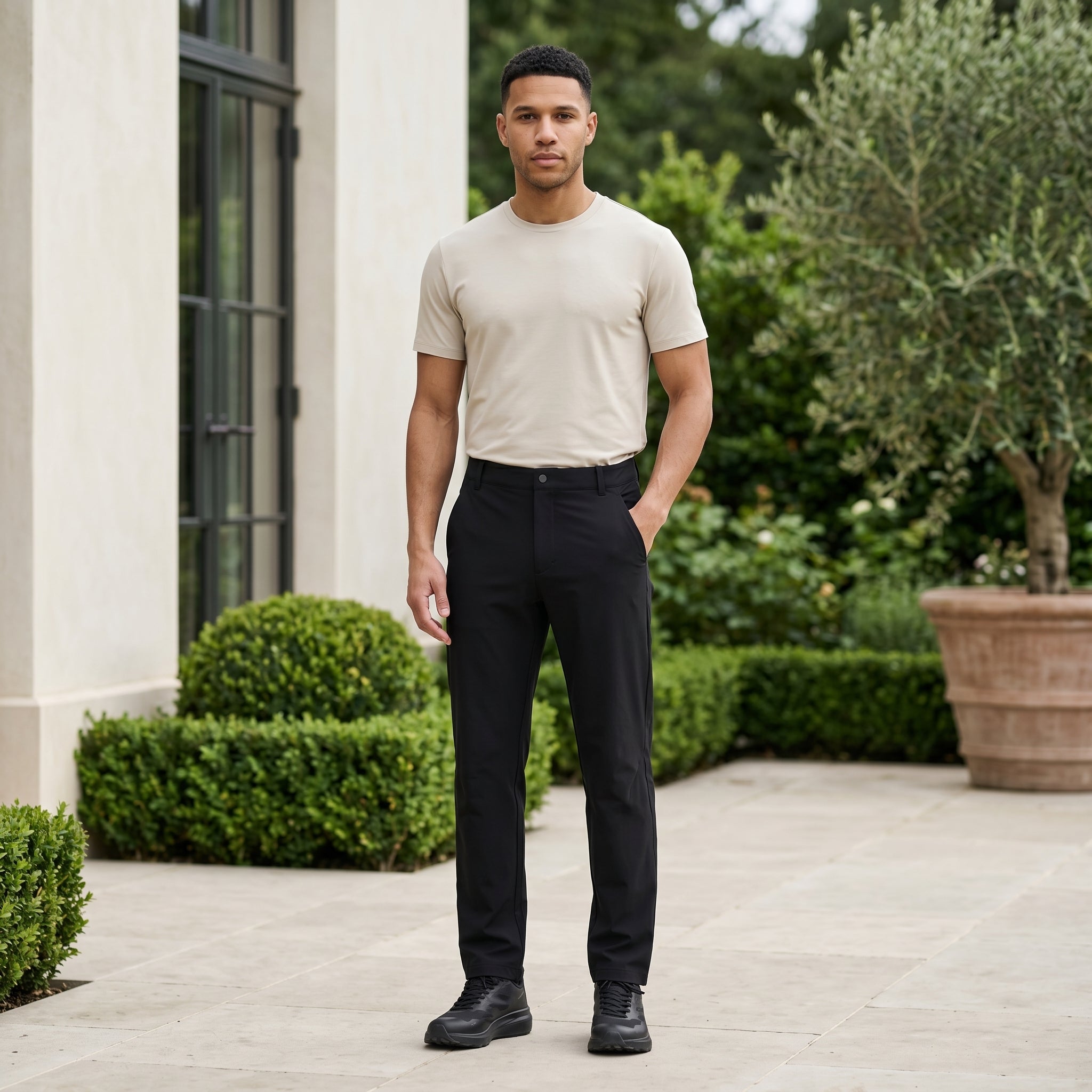 Man wearing a black men’s stretch pocketed pants with clean straight fit and button-front closure