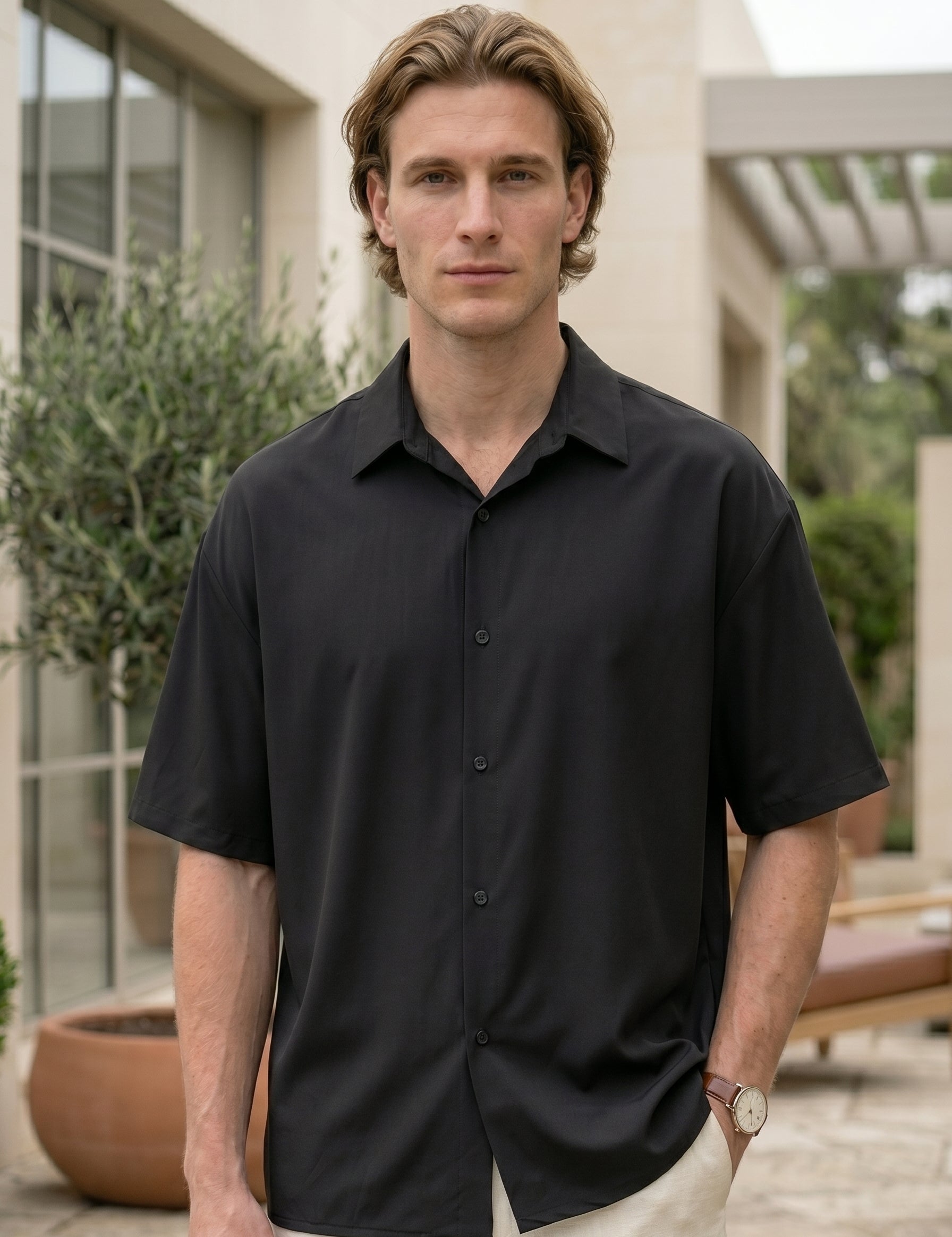 Man wearing a black short-sleeve shirt outdoors