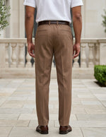 Man wearing a brown men’s pleated pocketed trousers with button waistband back view