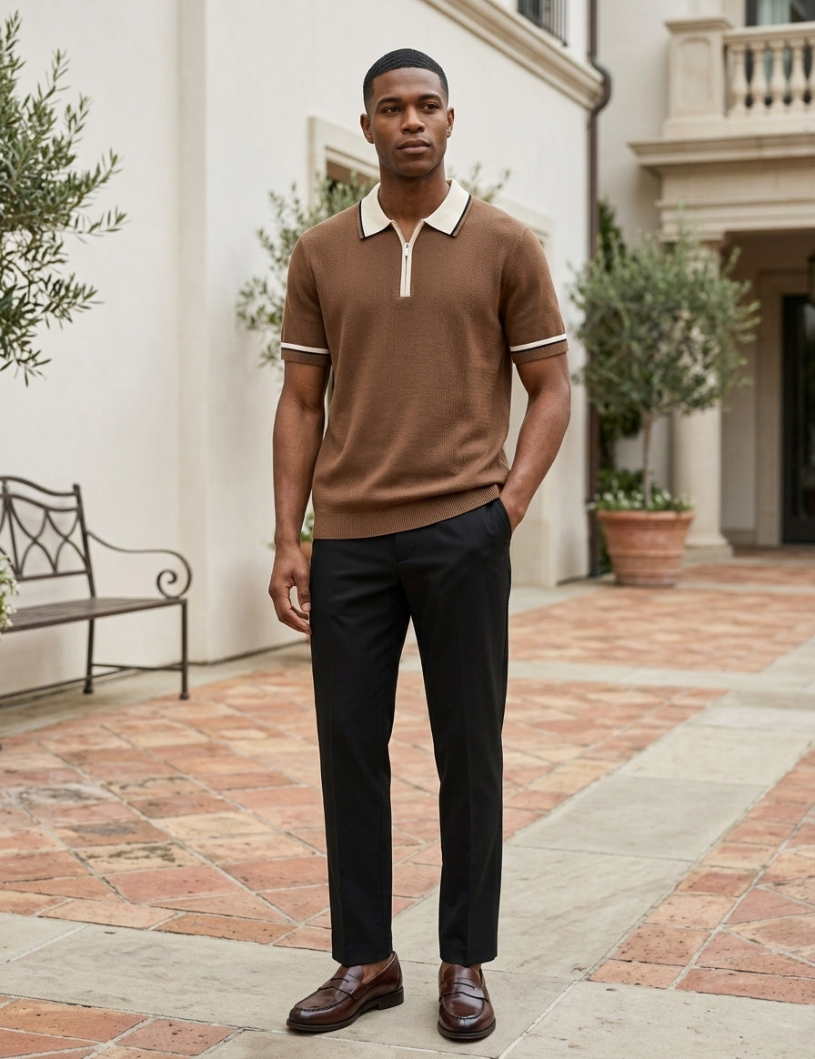 Man wearing a brown polo shirt and black pants standing in an outdoor setting.