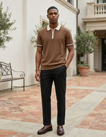 Man wearing a brown polo shirt and black pants standing in an outdoor setting.